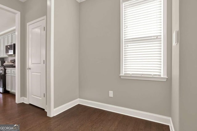 interior space with baseboards and dark wood-style flooring