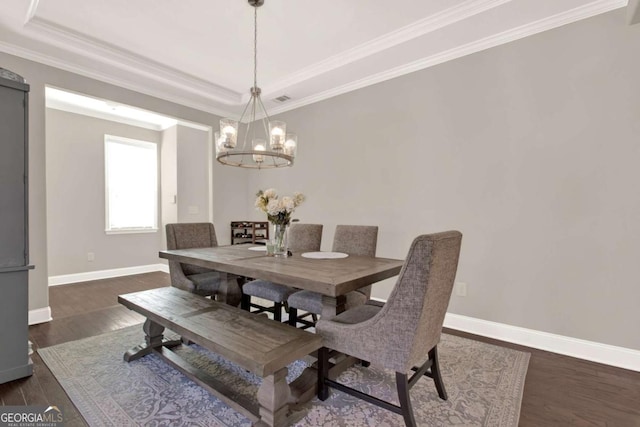 dining area featuring baseboards, a chandelier, a tray ceiling, ornamental molding, and wood finished floors