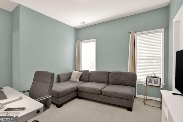 interior space with baseboards, visible vents, and light carpet