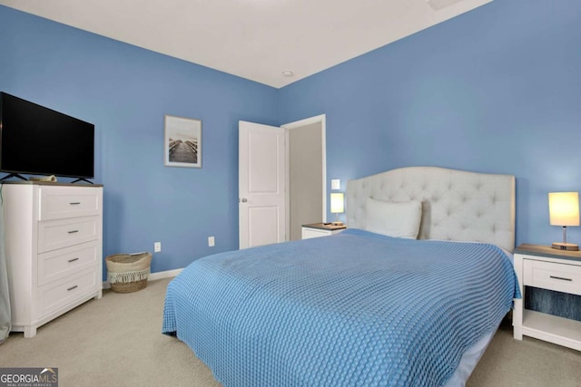 bedroom featuring light colored carpet and baseboards