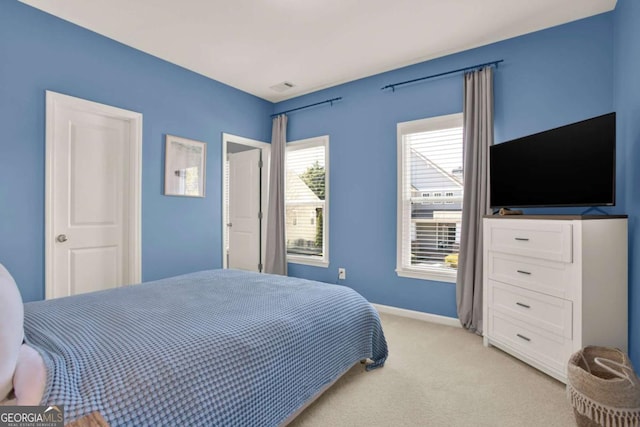 bedroom featuring visible vents, baseboards, and light colored carpet