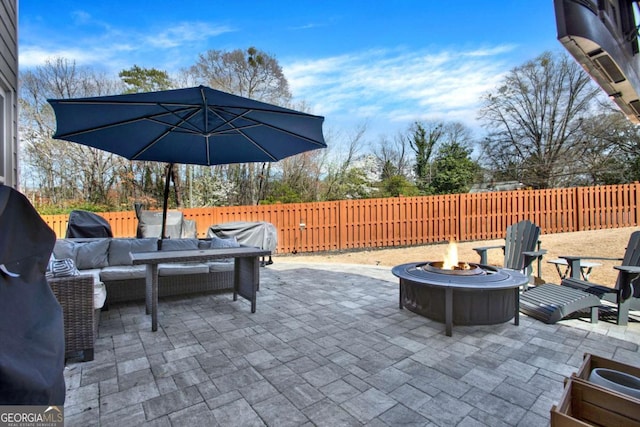 view of patio / terrace featuring an outdoor living space with a fire pit, a fenced backyard, and grilling area