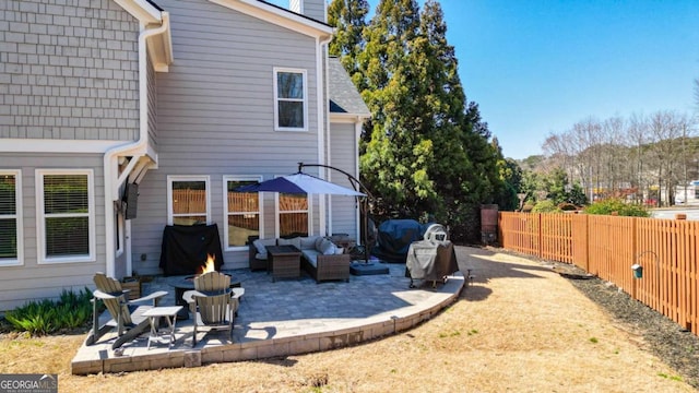 back of house with a chimney, fence private yard, outdoor lounge area, and a patio