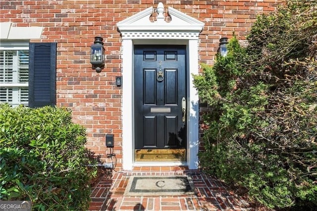 doorway to property featuring brick siding