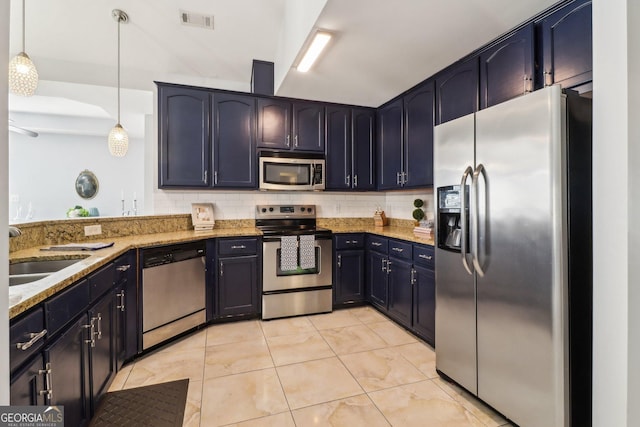 kitchen featuring visible vents, light stone counters, decorative backsplash, appliances with stainless steel finishes, and a sink