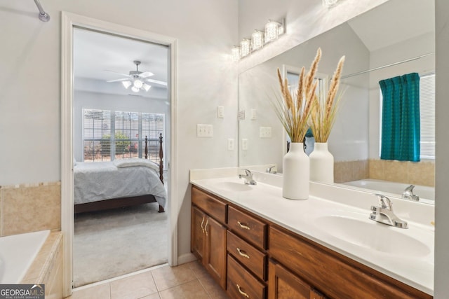 ensuite bathroom featuring a sink, double vanity, a bath, and tile patterned floors