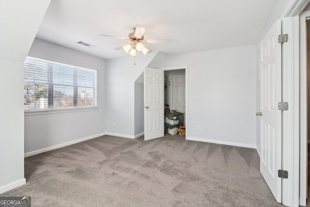 unfurnished bedroom with a ceiling fan, carpet, visible vents, and baseboards