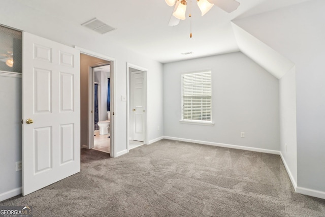 unfurnished bedroom with visible vents, baseboards, lofted ceiling, and carpet