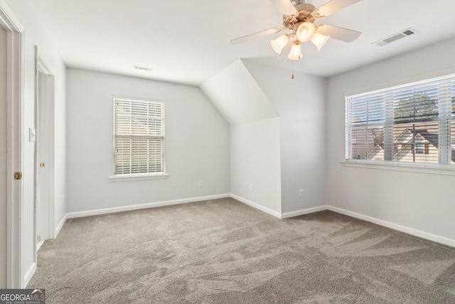 additional living space featuring visible vents, baseboards, carpet floors, lofted ceiling, and ceiling fan