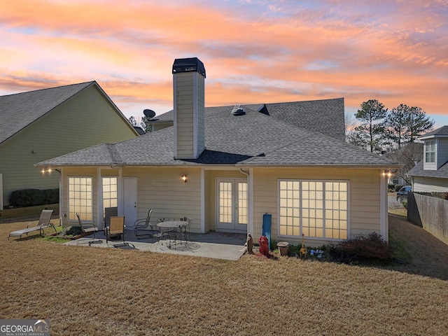 rear view of property with a patio, fence, french doors, a yard, and roof with shingles