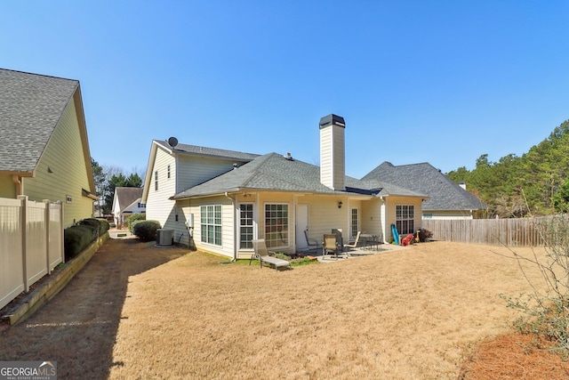 rear view of property featuring a patio area, a lawn, cooling unit, and a fenced backyard