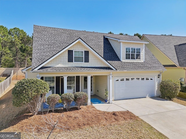 view of front of house featuring a garage, covered porch, concrete driveway, and a shingled roof