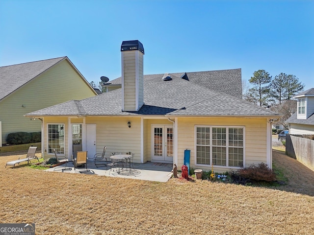 back of property featuring fence, french doors, a yard, a shingled roof, and a patio area