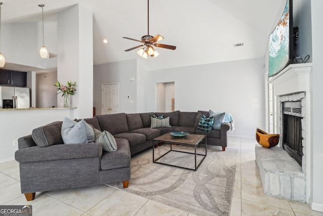 living room with ceiling fan, a premium fireplace, visible vents, and high vaulted ceiling