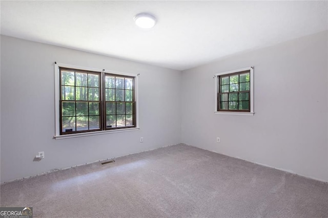 empty room with visible vents and carpet flooring