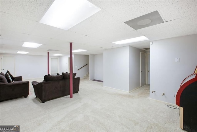 living area with baseboards, a paneled ceiling, carpet, and stairway