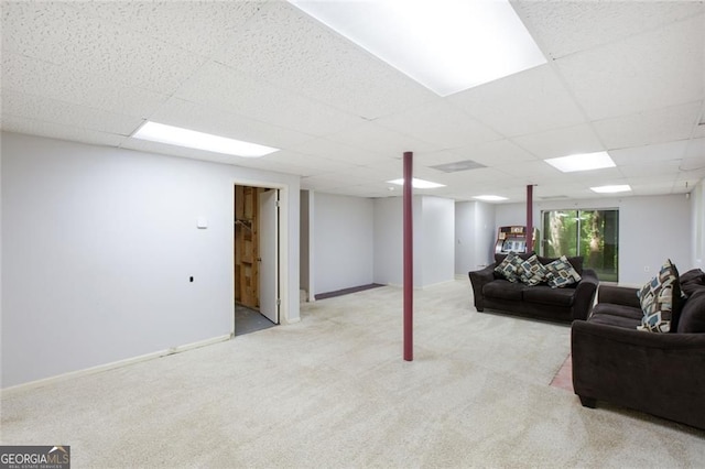 living area featuring carpet, baseboards, and a paneled ceiling