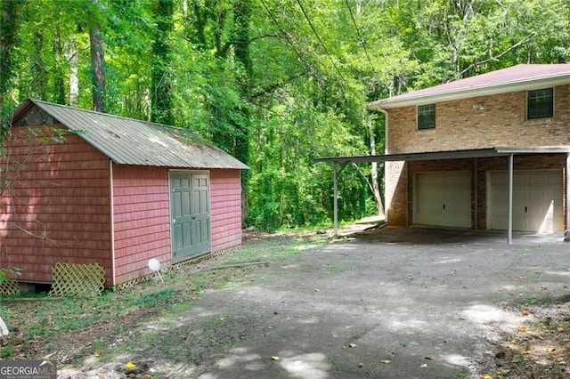 garage with a forest view and driveway