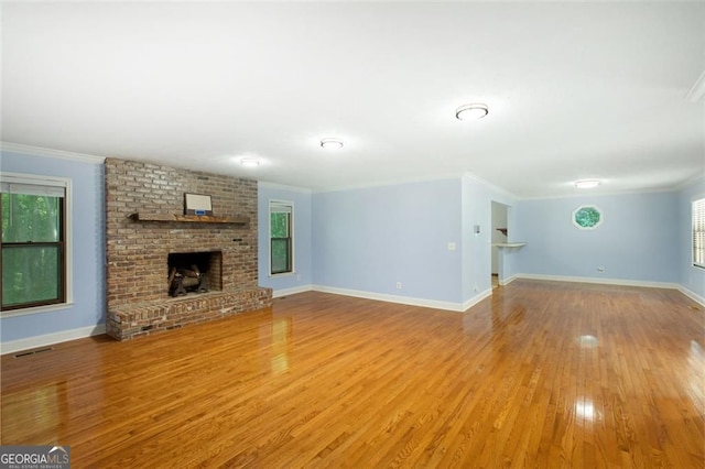 unfurnished living room with visible vents, baseboards, light wood-style flooring, a fireplace, and crown molding