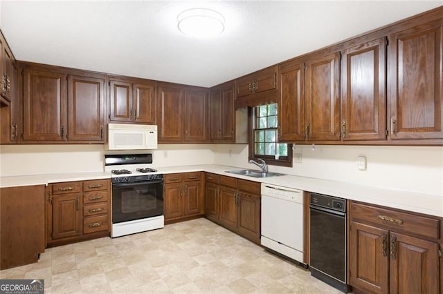 kitchen featuring white appliances, light countertops, light floors, and a sink