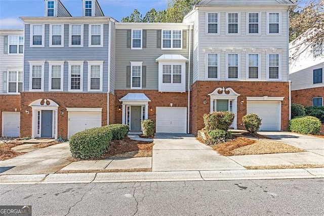 townhome / multi-family property with brick siding and driveway