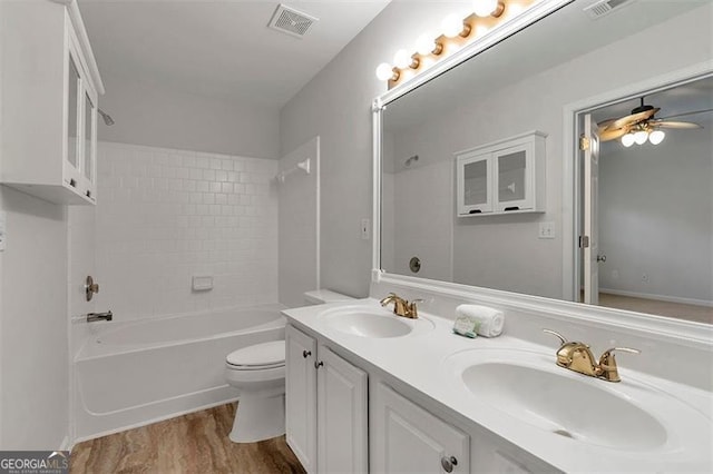 bathroom featuring a sink, visible vents, toilet, and a ceiling fan