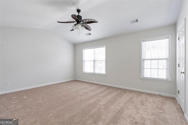 unfurnished room featuring visible vents, light colored carpet, and lofted ceiling