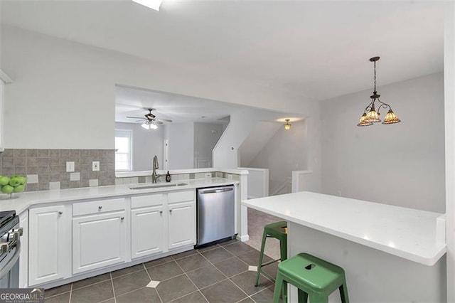 kitchen featuring a ceiling fan, white cabinetry, a peninsula, a sink, and stainless steel dishwasher