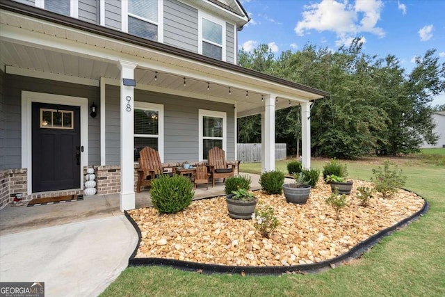 entrance to property featuring a porch and a yard