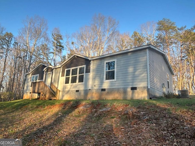 view of side of home featuring crawl space and central AC