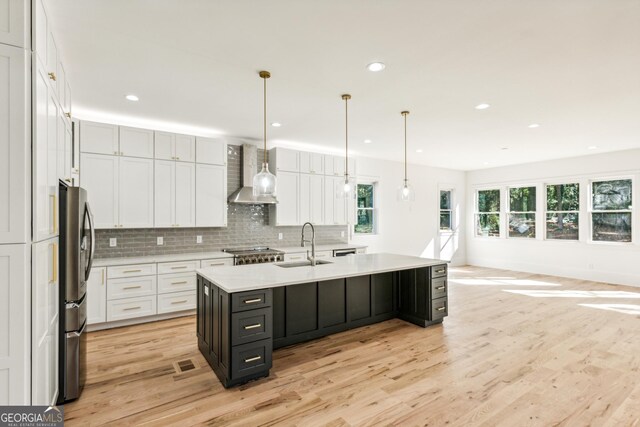 2611 Charlesgate Ave, Decatur, GA 30030 - kitchen with wall chimney range hood, freestanding refrigerator, light wood-style floors, light countertops, and recessed lighting