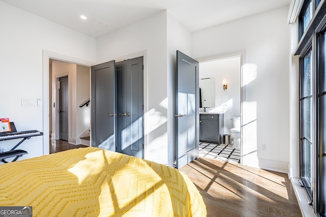 bedroom featuring baseboards, recessed lighting, wood finished floors, a closet, and connected bathroom