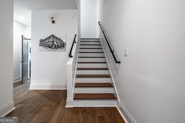 staircase with baseboards and wood finished floors