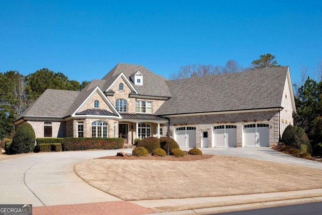 view of front facade with concrete driveway, metal roof, a garage, stone siding, and a standing seam roof