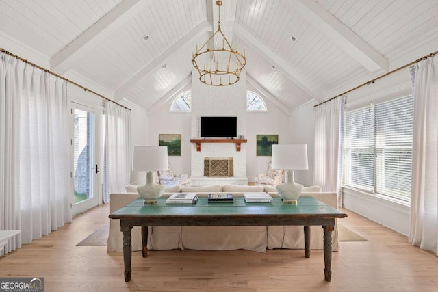 living room with a notable chandelier, beamed ceiling, high vaulted ceiling, and light wood-style floors