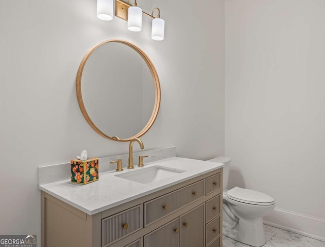 bathroom featuring baseboards, toilet, marble finish floor, and vanity