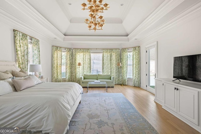 unfurnished bedroom with light wood-type flooring, a raised ceiling, ornamental molding, and access to exterior