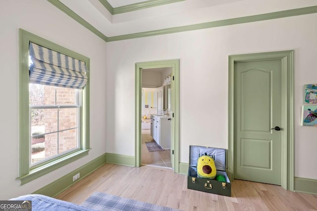 bedroom with multiple windows, crown molding, baseboards, and wood finished floors