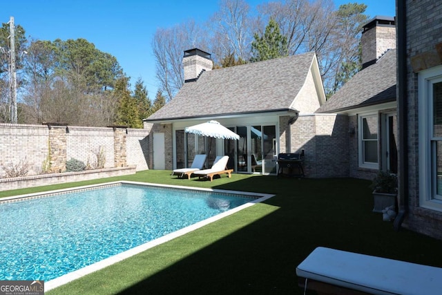 view of swimming pool featuring area for grilling, a fenced in pool, a yard, and fence