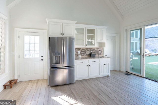 kitchen with a sink, stainless steel fridge, light wood-style floors, and plenty of natural light