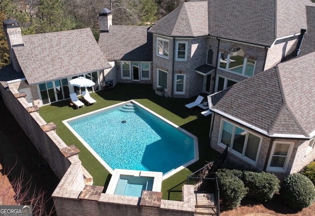 view of swimming pool with a patio, a lawn, and a pool with connected hot tub