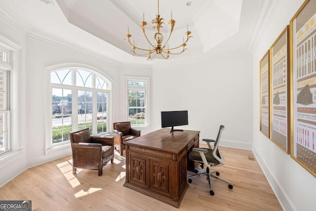 office space featuring a tray ceiling, an inviting chandelier, crown molding, and light wood finished floors