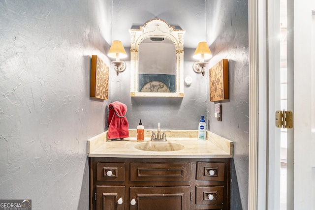 bathroom with vanity and a textured wall