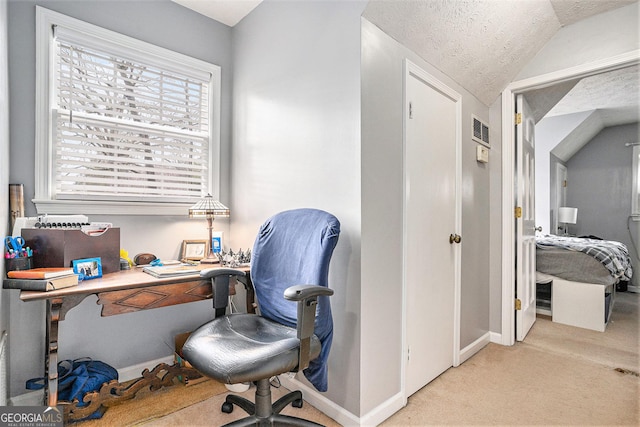 office with visible vents, baseboards, vaulted ceiling, a textured ceiling, and light carpet