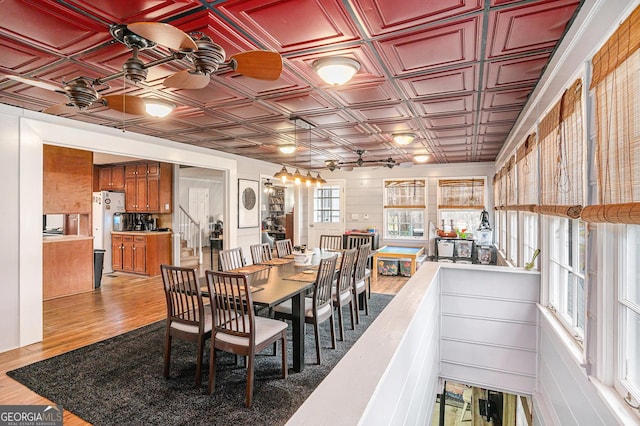 dining room with light wood finished floors and an ornate ceiling