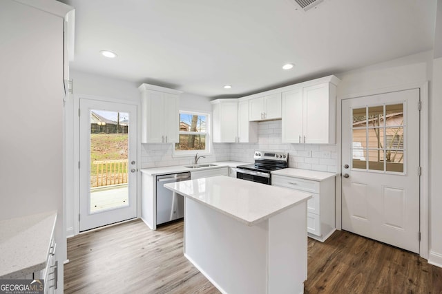 kitchen featuring dark wood finished floors, tasteful backsplash, appliances with stainless steel finishes, and a sink