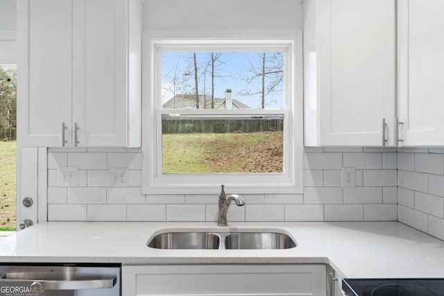 kitchen with dishwasher, white cabinets, a healthy amount of sunlight, and a sink