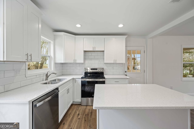 kitchen with a sink, plenty of natural light, appliances with stainless steel finishes, and a center island