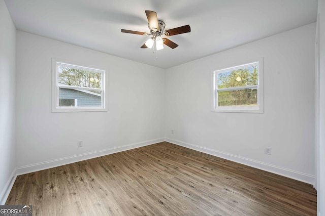 spare room featuring a ceiling fan, baseboards, and wood finished floors