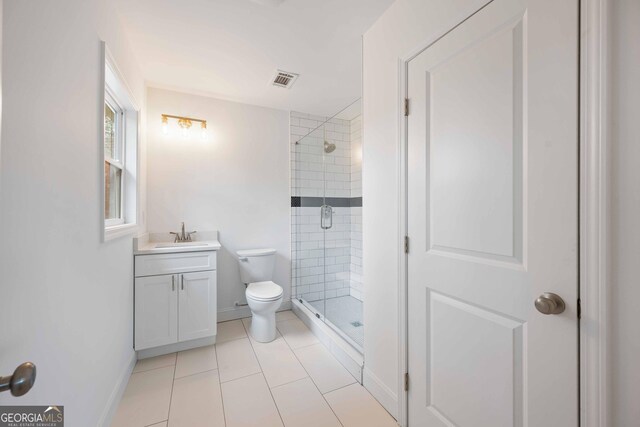 full bathroom with vanity, baseboards, a stall shower, tile patterned flooring, and toilet